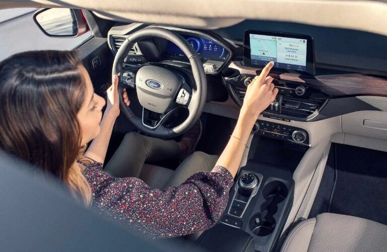 Woman operating centre touchscreen of 2020 Ford Escape Titanium