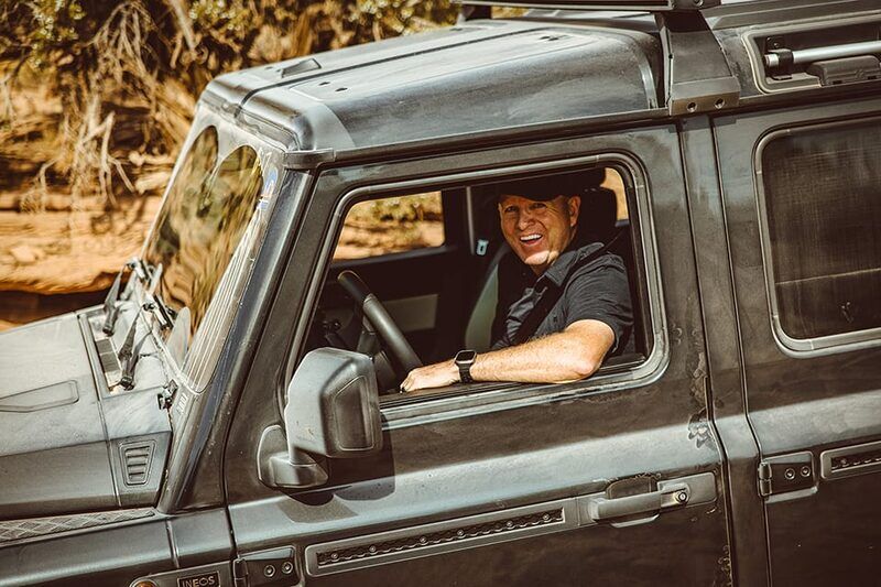 Smiling owner leaning out the window of a Grenadier at Oktoberfest 2024 in Moab