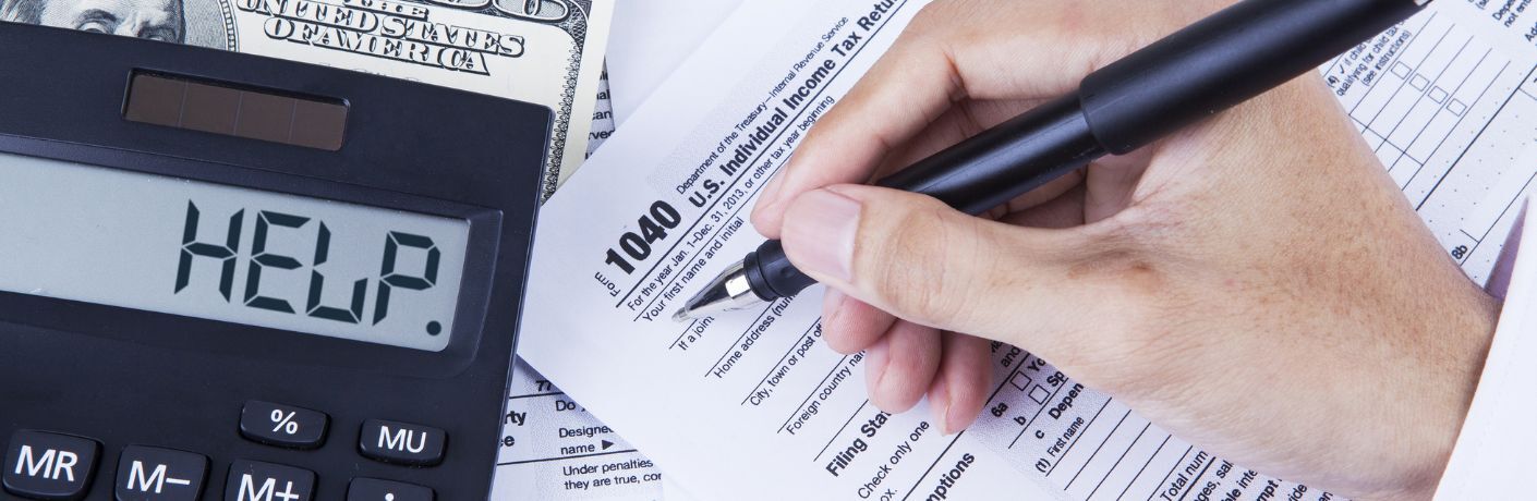 a hand filling out a form next to a calculator