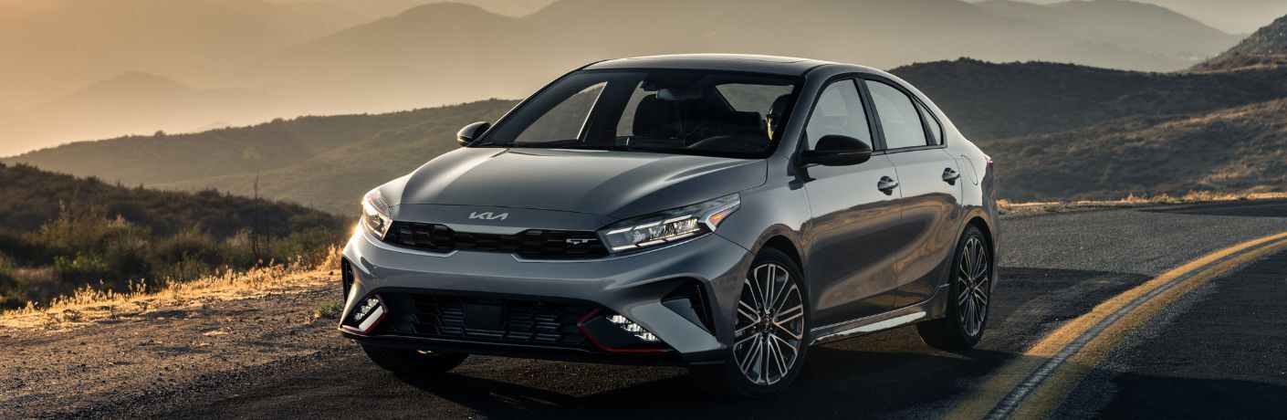 A 2024 Kia Forte backdropped by a sunset