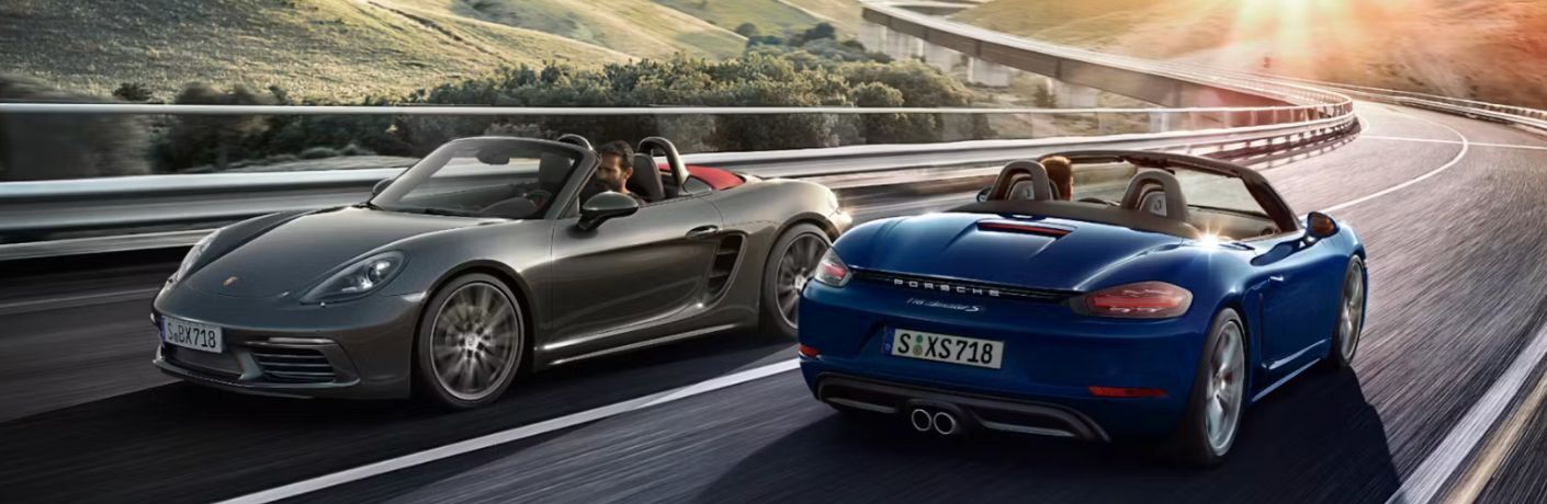 two 2025 Porsche 718 Boxster crossing each other on a road