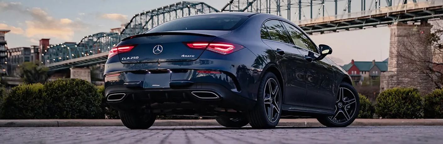 Rear view of the 2023 Mercedes-Benz CLA 250 4MATIC® Coupe under a walkway bridge