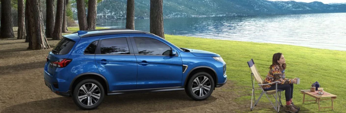 Girl enjoying her coffee outdoors with the 2024 Mitsubishi RVR GT