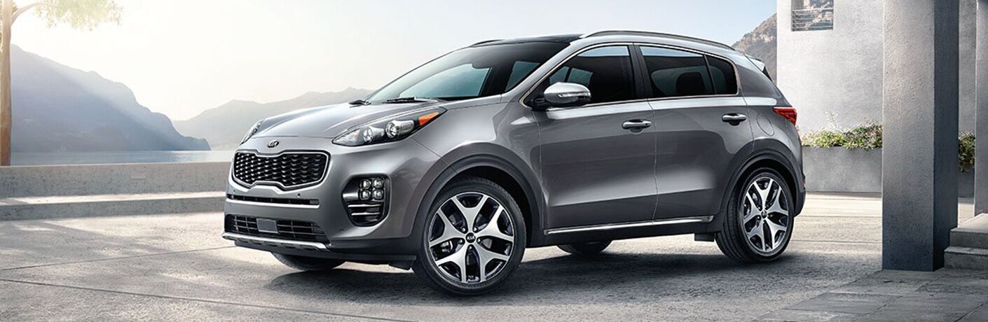 Profile view of silver 2019 Kia Sportage parked in front of modern house