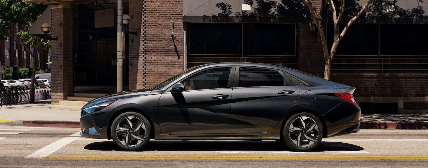 Grey 2021 Hyundai Elantra parked at a stop sign on a city street