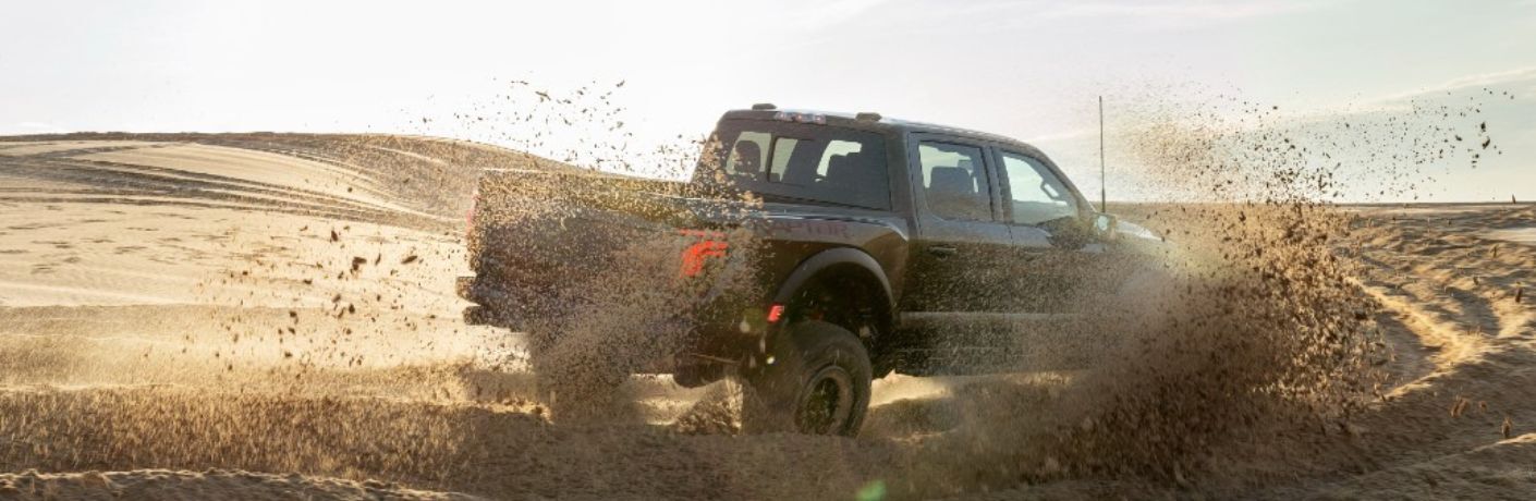 2024 Ford F-150 Raptor rear and side view driving in sand