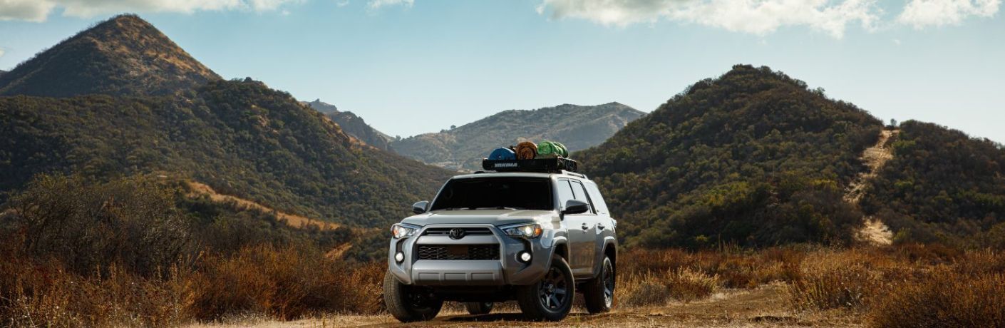 One grey color 2021 Toyota 4Runner is running on a road surrounded by green mountains.