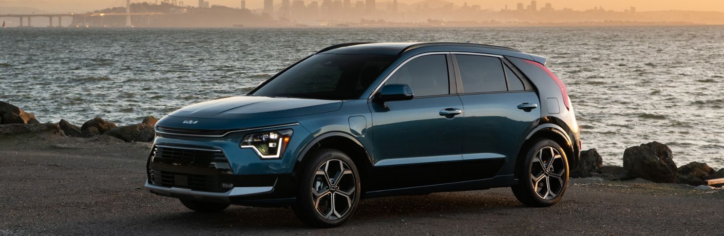 A 2024 Kia Niro Plug-In Hybrid on the bank of a lake