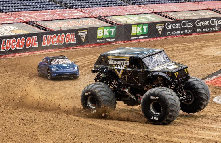 Porsche Taycan Turbo S Cross Turismo and the Monster Jam Truck on a dirt track