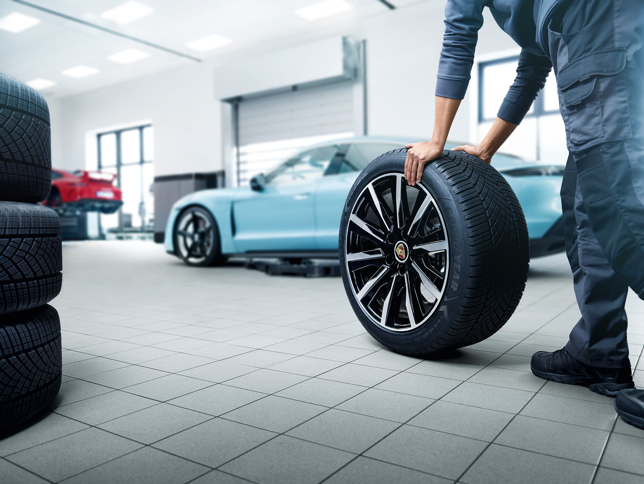 porsche certified tech champion porsche rolling a porosche wheel past a taycan