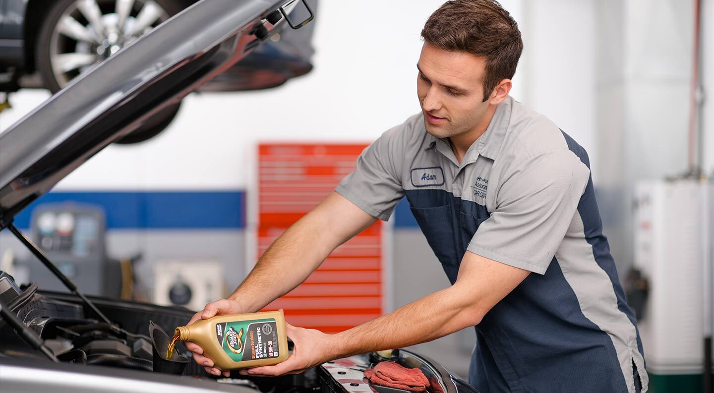 Service technician changing oil in Hyundai vehicle