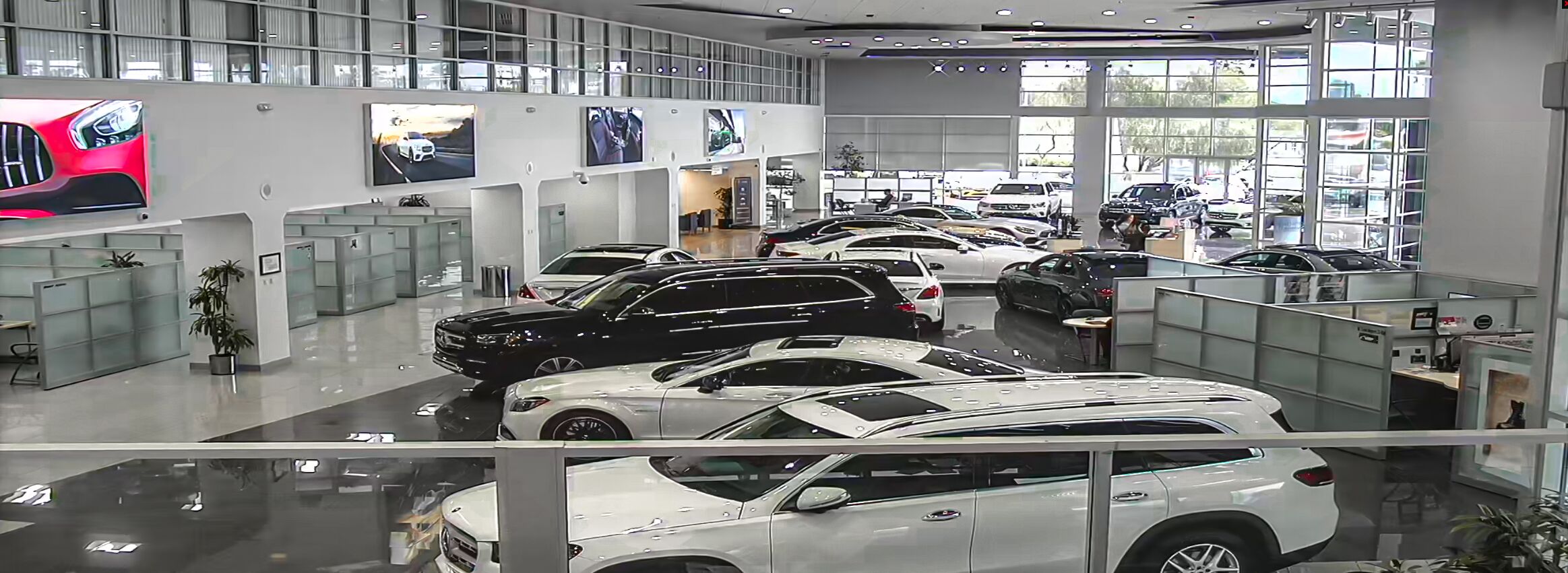 Car dealership lot with cars parked and sun shining