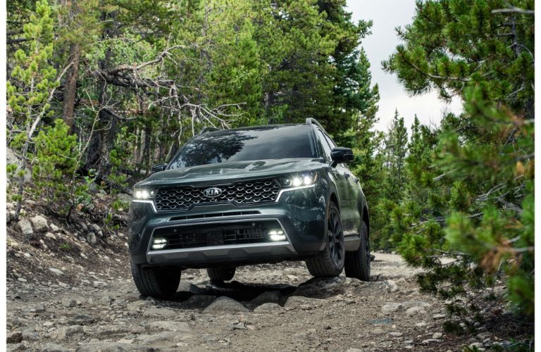 2021 Kia Sorento exterior front shot of grille and headlights driving on a forest trail