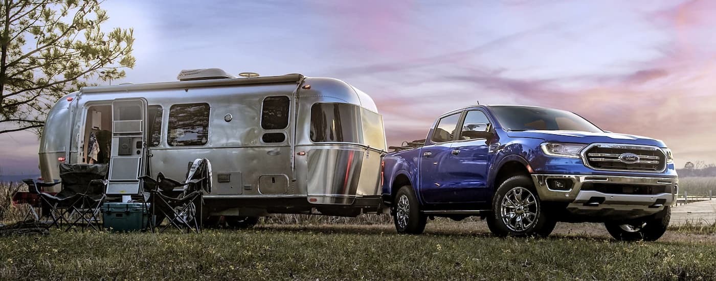 Blue 2023 Ford Ranger at a campsite with a silver camper trailer