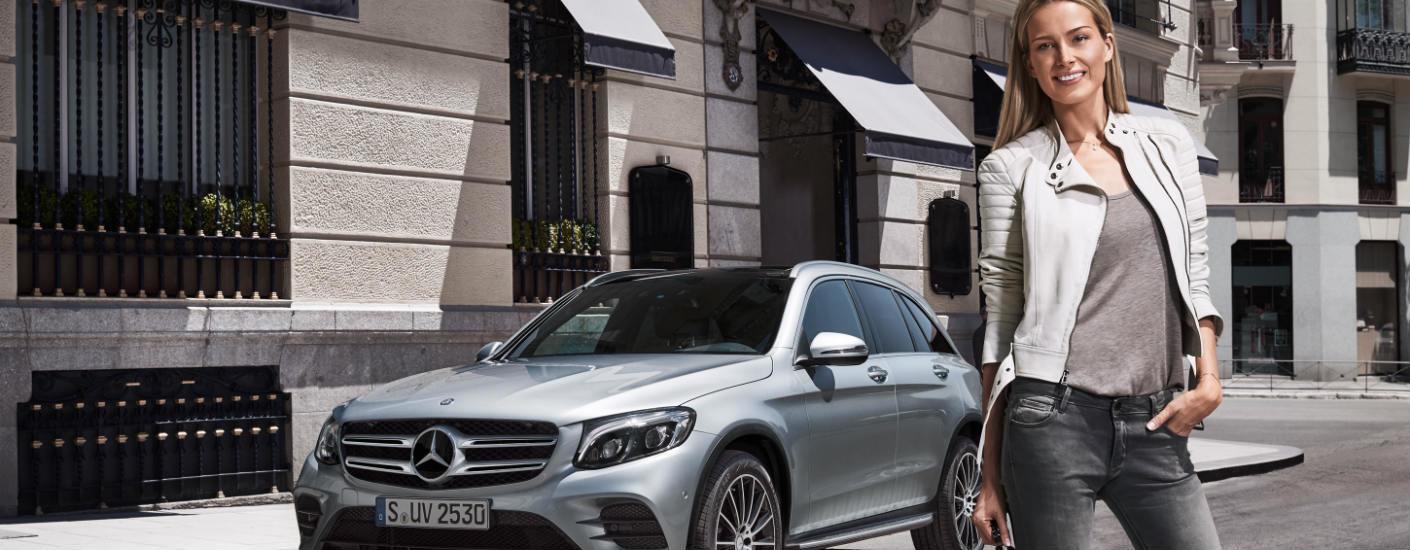 woman standing next to silver Mercedes-Benz wagon