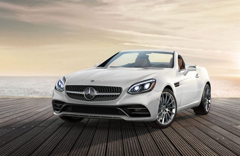 white mercedes-benz slc roadster parked by the ocean