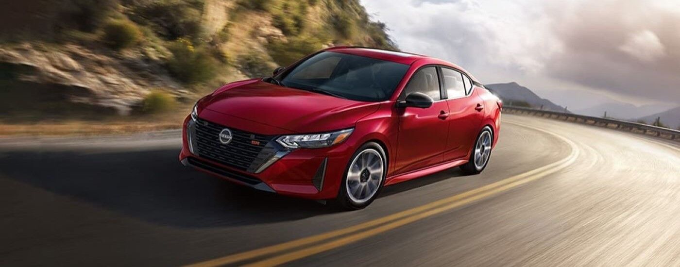 Red 2024 Nissan Sentra SR driving around a bend.