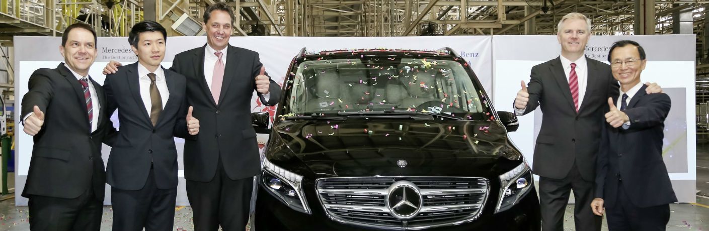 people giving a thumbs up next to a mercedes-benz