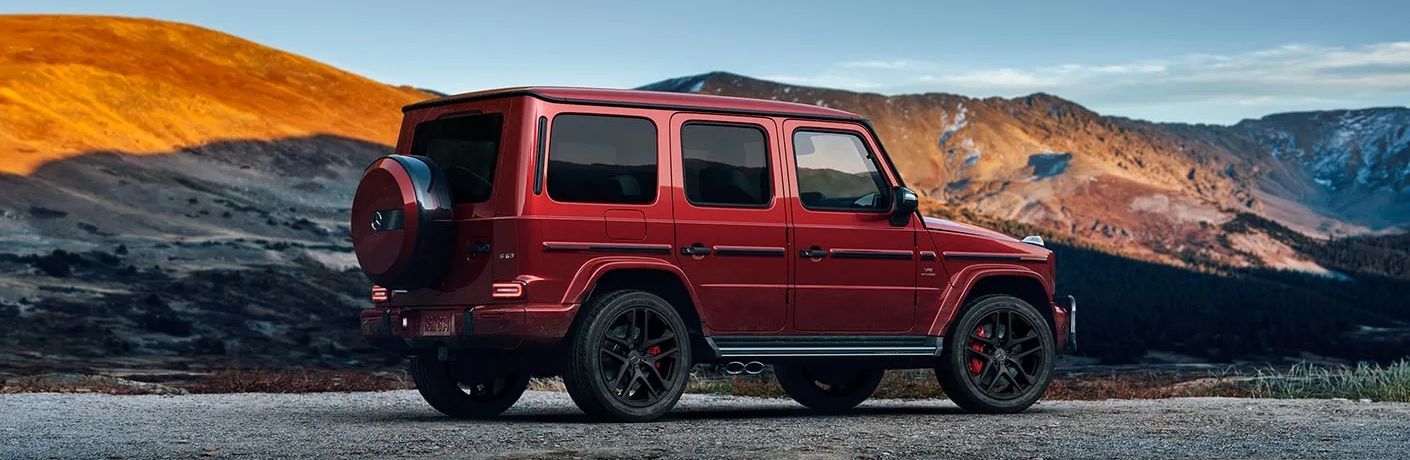 Side view of the 2024 Mercedes-Benz AMG® G 63 in MANUFAKTUR Cardinal Red