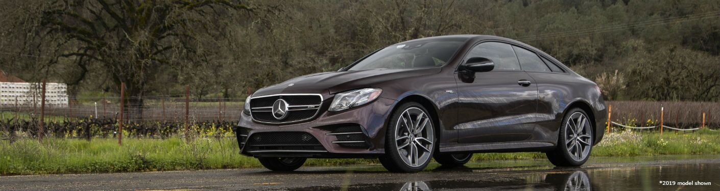 2020 MB E-Class Coupe exterior front fascia and driver side in front of grassy and trees