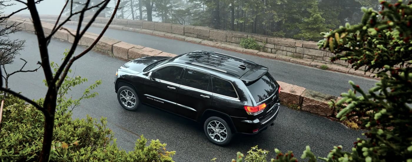 A black 2022 Jeep Grand Cherokee WK driving on a foggy road.