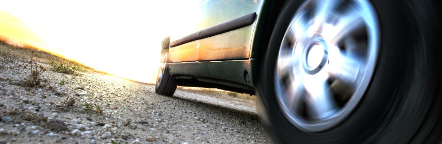 Low-angled image of a vehicle on a gravel road