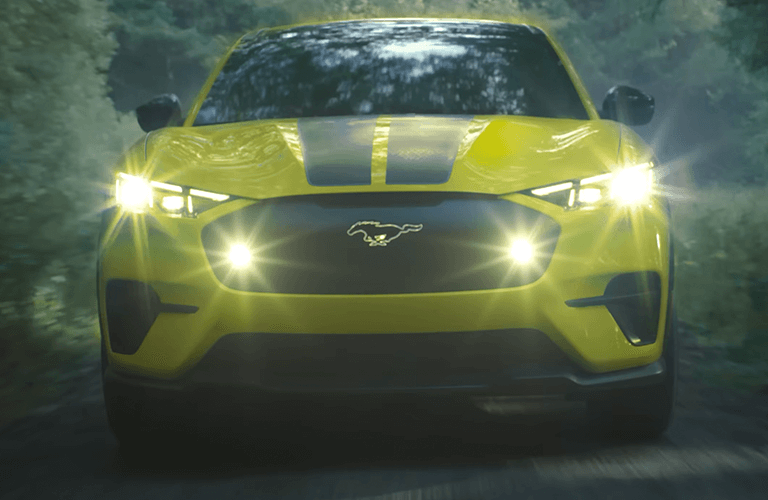 2024 Ford Mustang Mach-E Rally model in yellow with headlights on