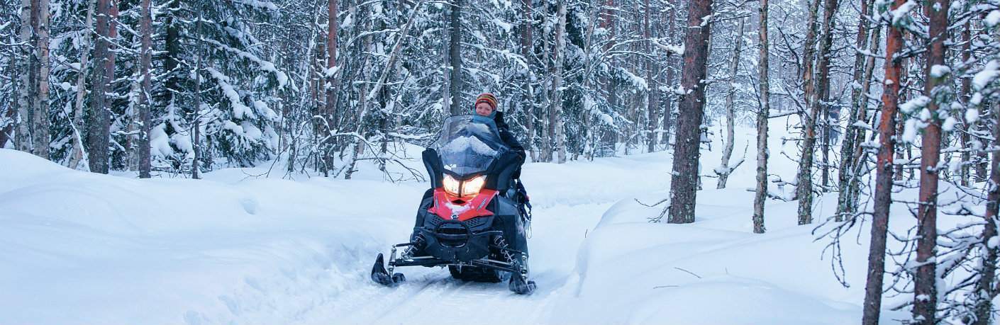 Snowmobiler on a wooded trail