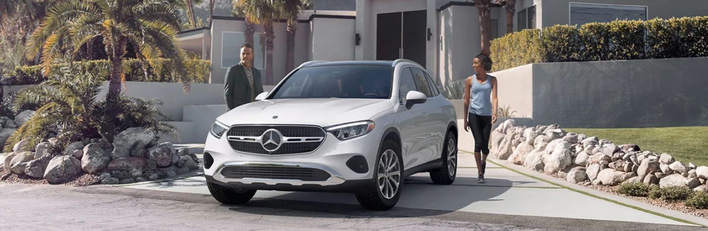 The 2024 Mercedes-Benz GLC is parked in front of a house with family nearby.