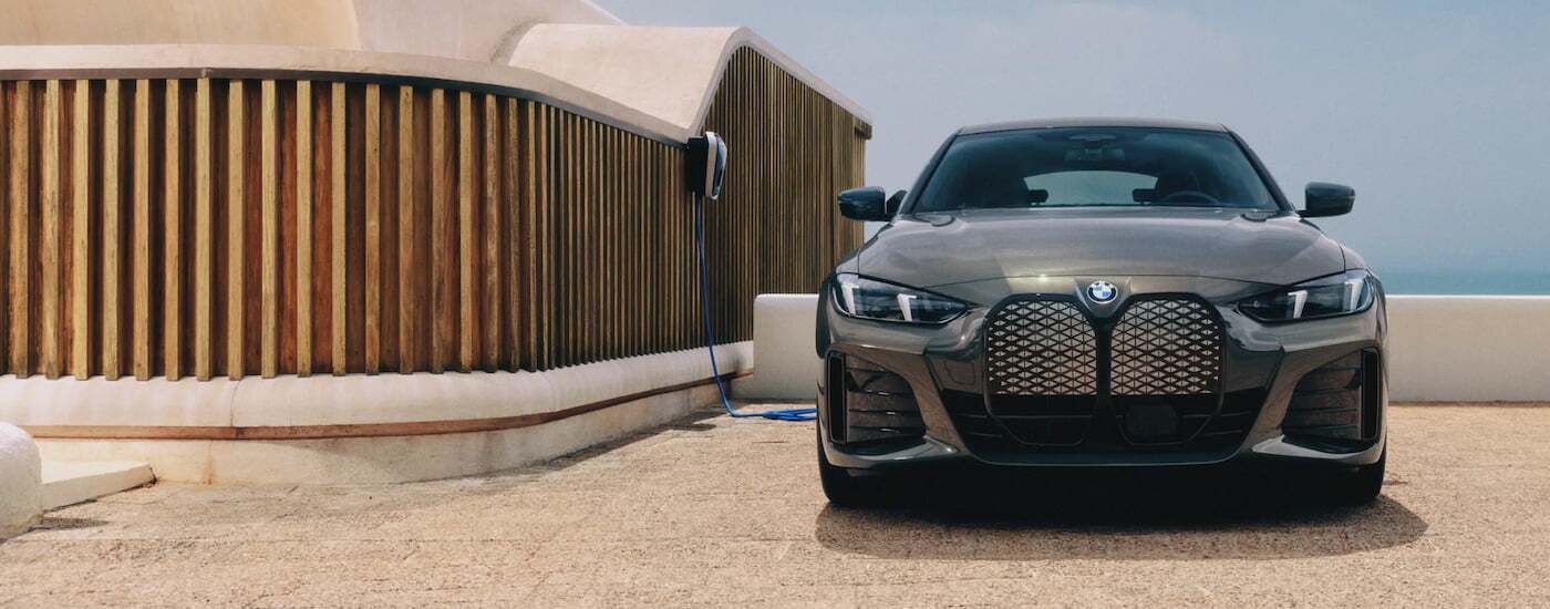 Front view of a brown 2026 BMW i4 Gran Coupe parked and charging.