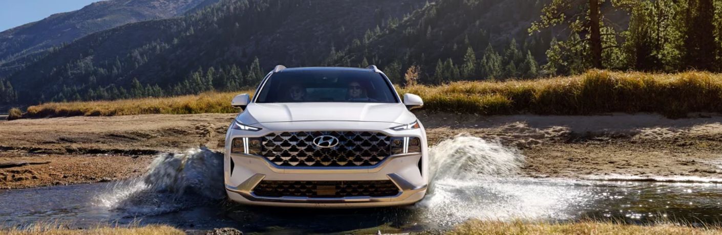 A 2023 Hyundai Santa Fe splashing through a ford