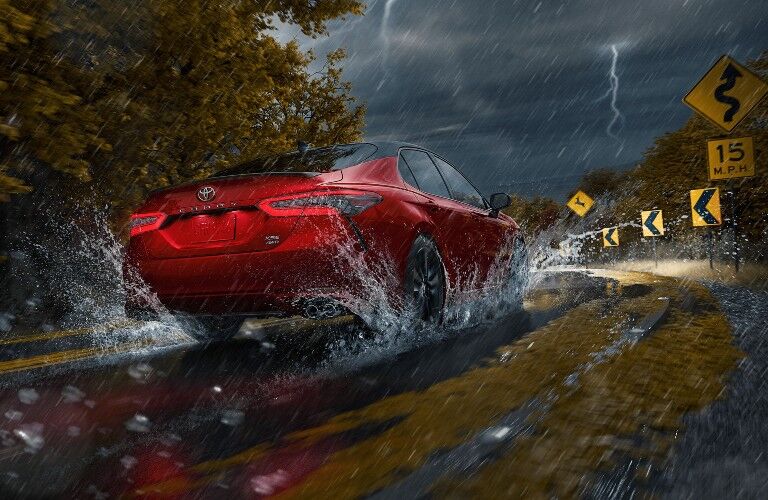 2021 Toyota Camry red driving in storm around corner