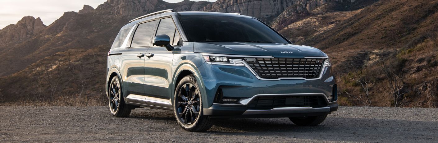 A 2024 Kia Carnival backdropped by rocky mountains