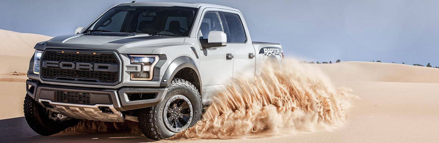 ford pickup truck kicking up sand in the desert