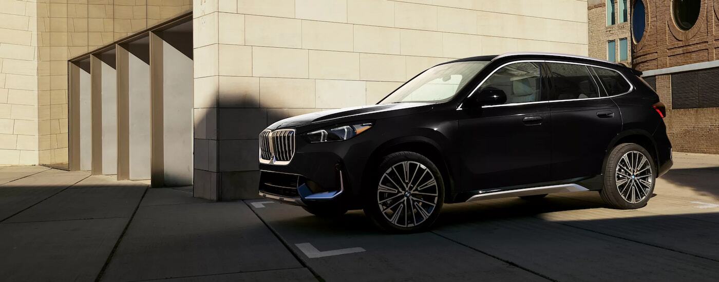 Black 2026 BMW X1 parked near a garage.