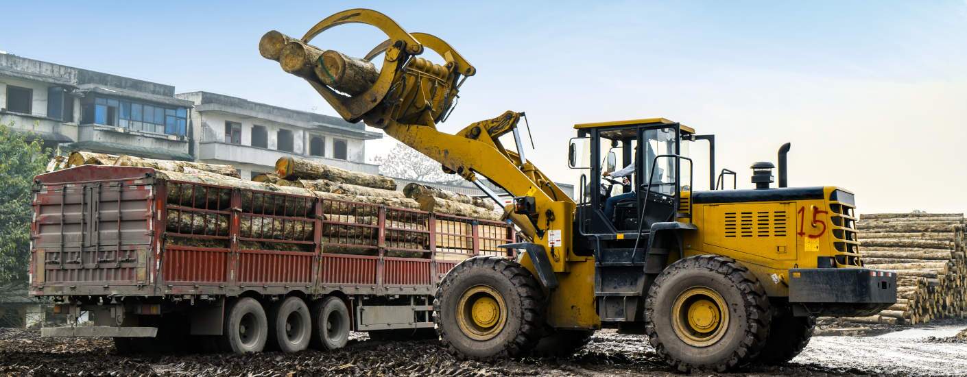 A grapple truck picking up a load.