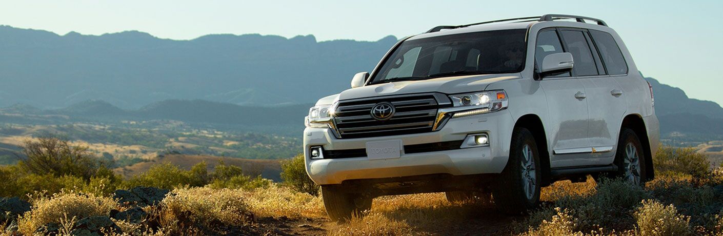 white toyota land cruiser parked in desert brush area