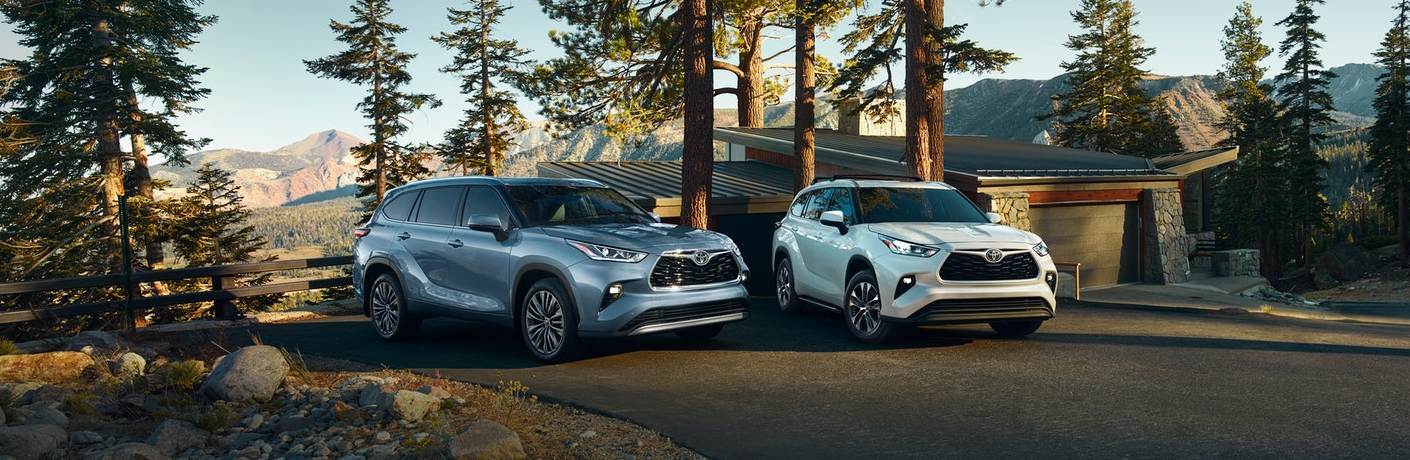Two 2020 Toyota Highlander vehicles parked near a building in the wilderness