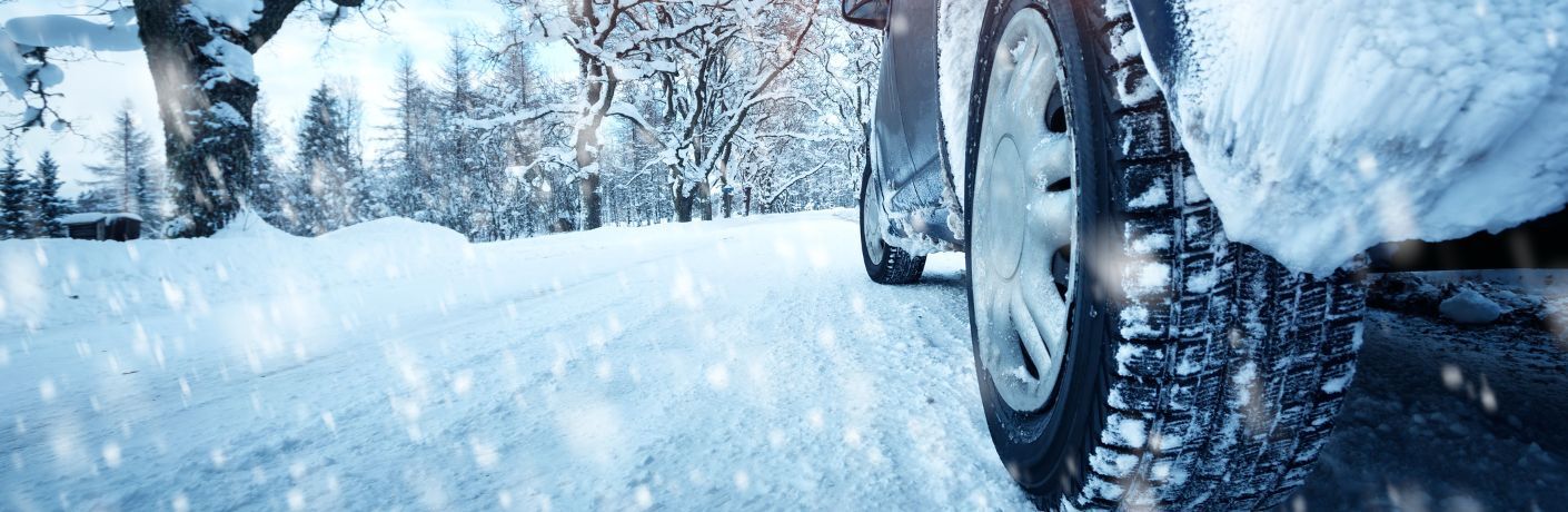 Close up of a car tire on a snow covered road