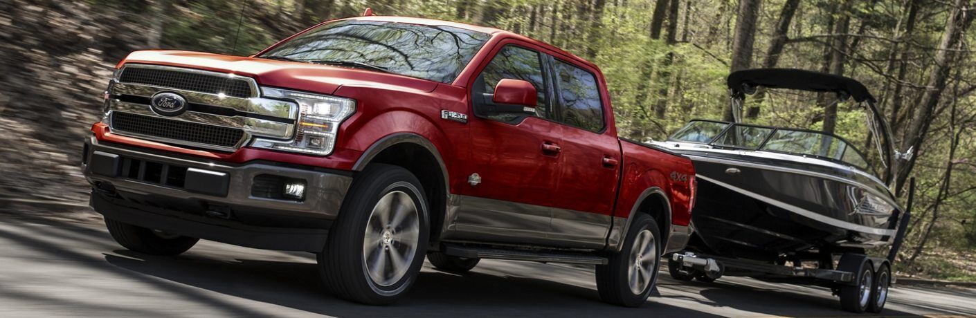 Front driver angle of a red 2020 Ford F-150 towing a boat