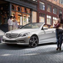 People approaching a parked Mercedes-Benz car
