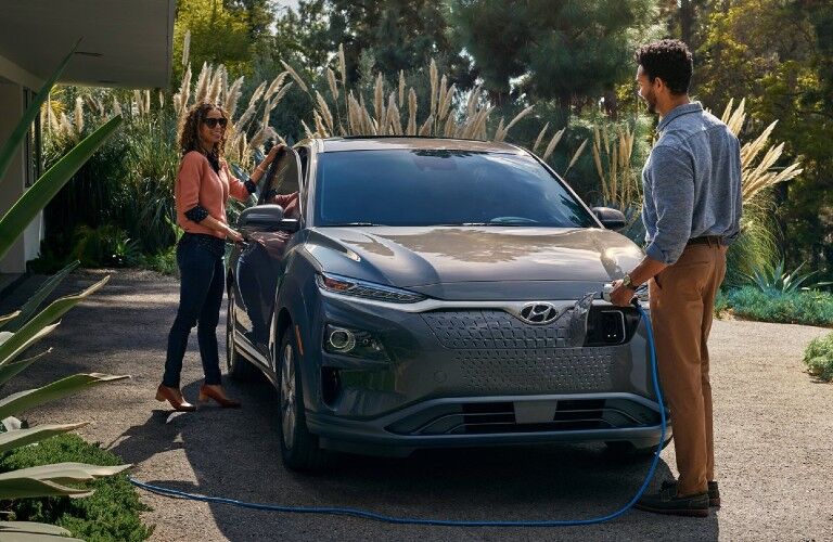 Front passenger angle of a gray 2021 Hyundai Kona EV being charged