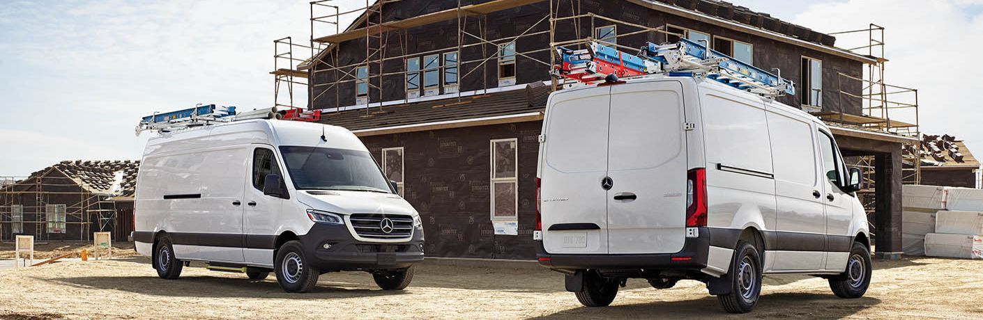 Two 2027 Mercedes-Benz Sprinter Vans standing in front of a construction site