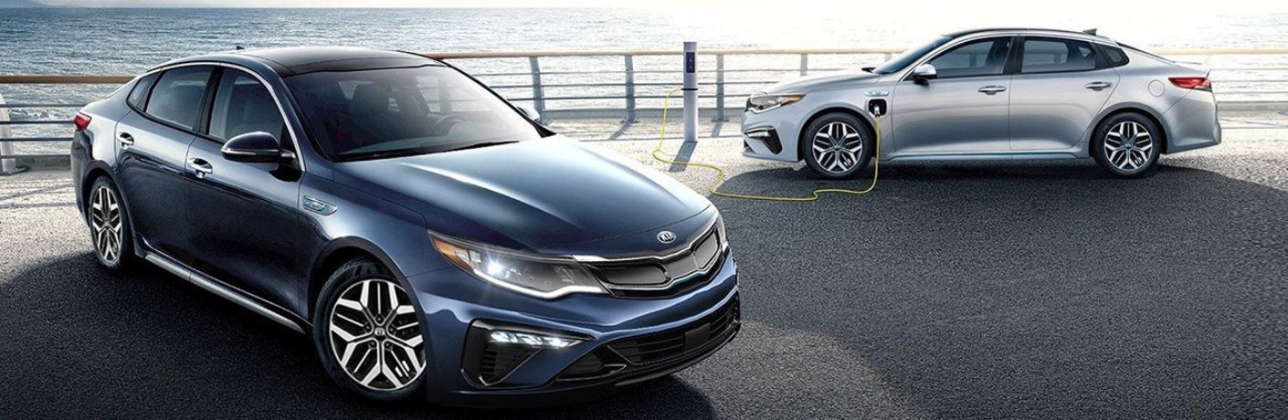 Exterior view of a blue 2020 Kia Optima Hybrid and a silver 2020 Kia Optima Hybird