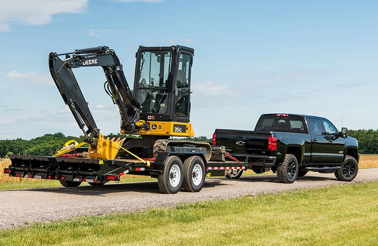 Black 2018 Chevy Silverado 2500HD Towing a Backhoe