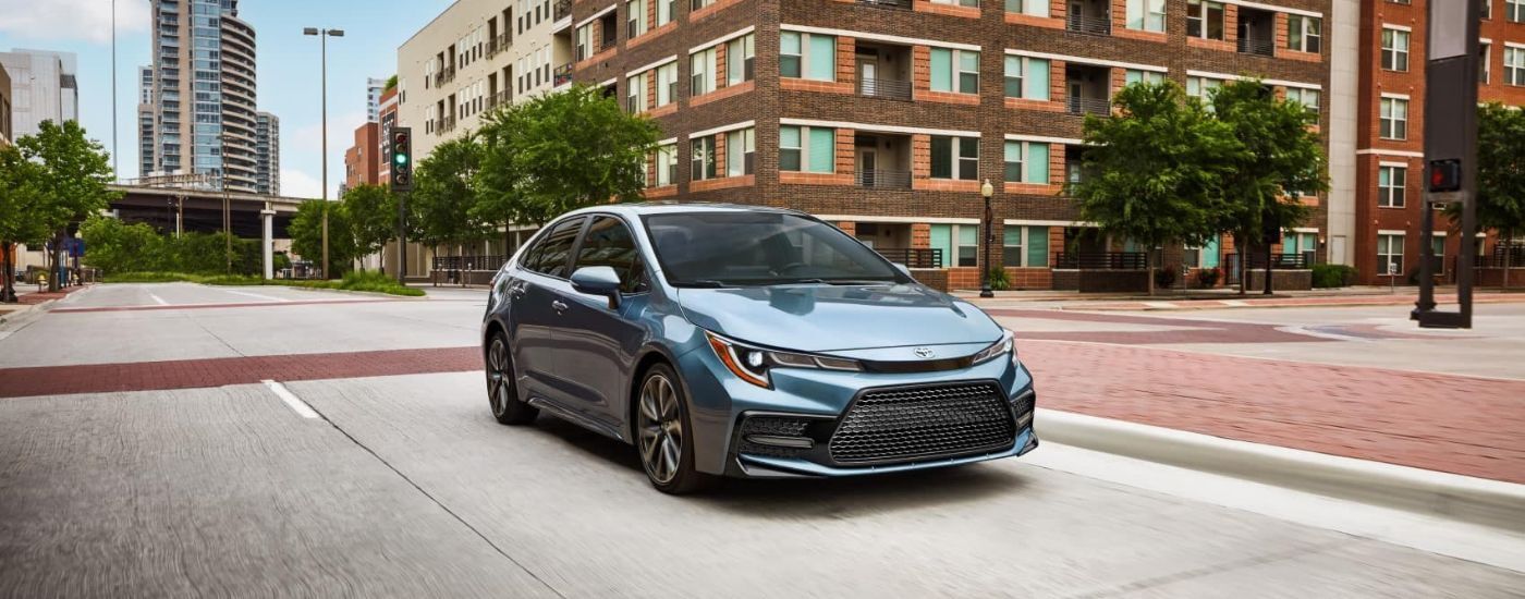 Blue 2022 Toyota Corolla XSE driving down a city street.