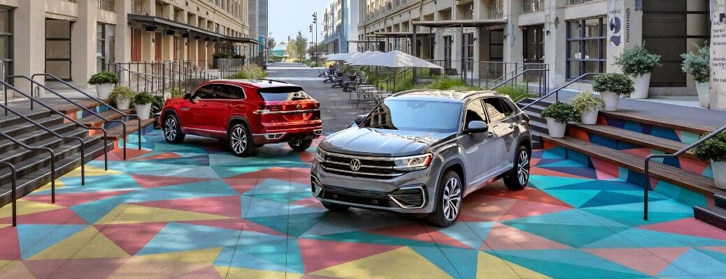 Two Volkswagen SUVs parked in a colorful plaza