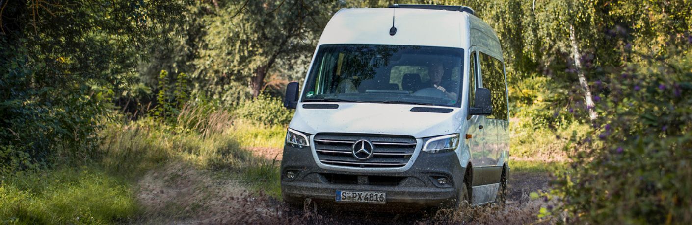 Front view of the 2023 Mercedes-Benz Sprinter Passenger Van in a forest