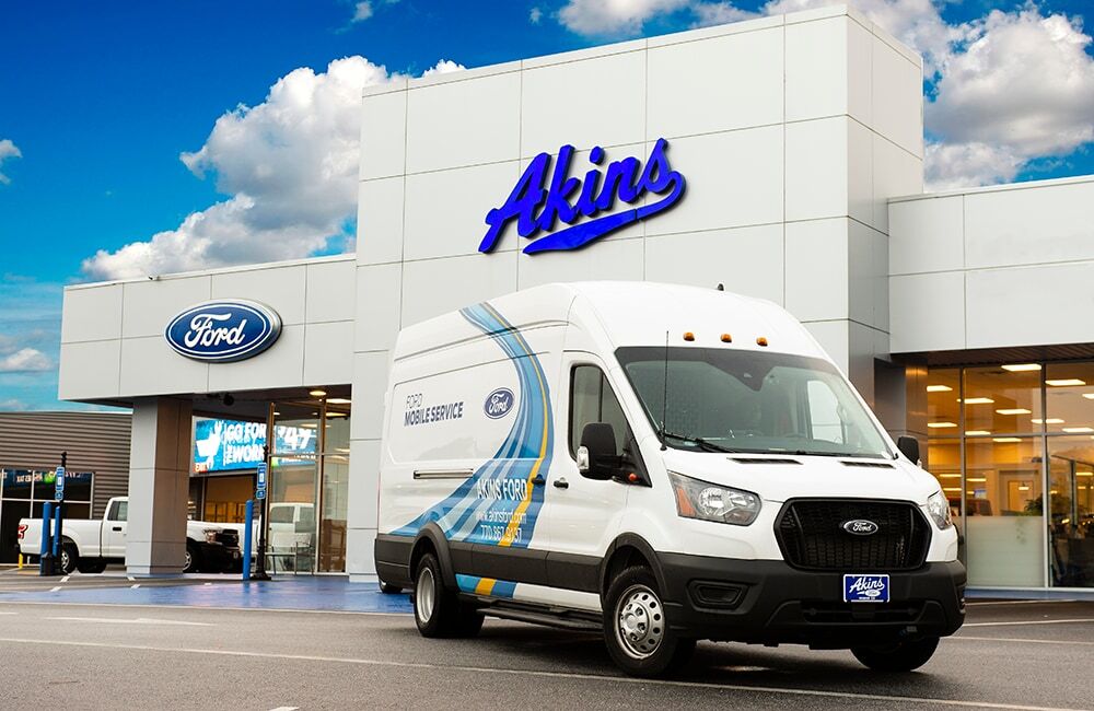 A Ford mobile service van parked in front of the Akins Ford dealership