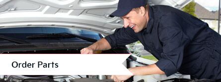 mechanic working under hood of car